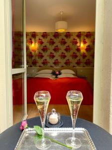 Château D'Apigné Rennes في لو رو: كأسين من الشمبانيا على طاولة في غرفة النوم