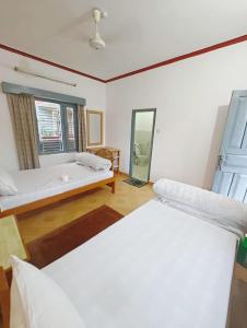 Hotel Mountain View - Lakeside Pokhara في بوخارا: غرفة بسريرين وحوض استحمام