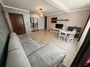 - un salon avec un canapé et une table dans l'établissement Apartments in Solid House Mamaia, à Mamaia