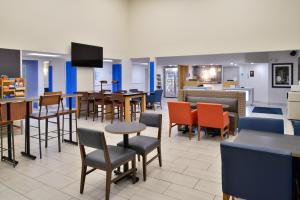 un restaurante con mesas y sillas y una cafetería en Holiday Inn Express Hotel & Suites Farmington, an IHG Hotel, en Farmington