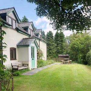 a house with a bench and a picnic table in the yard at Llynhillyn Cottage in Presteigne +22 photos