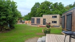 un patio trasero con una casa de piedra con patio en Tiny Haus Park Fritzlar en Fritzlar