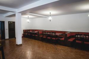 a room with a row of wooden seats in a church at Cabana Iulian in Petrila