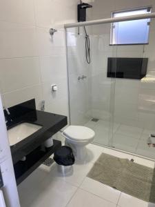 a bathroom with a shower and a toilet and a sink at Casa Capitólio com Vista para Escarpas do Lago in Capitólio +23 photos