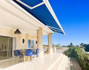un patio con sedie blu e un tavolo su una casa di Chambre double à la Marina a La Marina