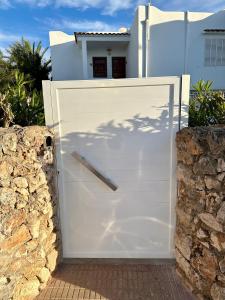 una puerta de garaje blanca frente a una casa en Sunset en Cala D'Or