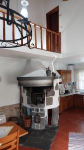 a living room with a stone fireplace with a staircase at Casa do Granel in Sete Cidades