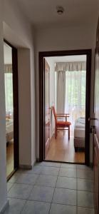 a living room with a door open to a room with a chair at PSZ Hotel Beach Földvár in Balatonföldvár