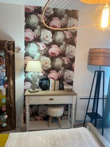 1 dormitorio con escritorio y papel pintado de flores en Petit cocon proche de Stanislas, en Nancy