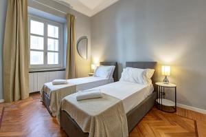 a bedroom with two beds and a window at IREX Colosseo & Fori, Elegant 3 rooms apartment in Rome