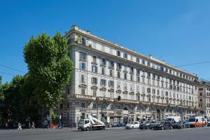 a large building with cars parked in front of it at IREX Colosseo & Fori, Elegant 3 rooms apartment in Rome