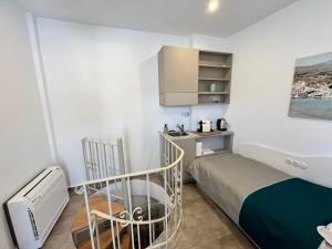 1 dormitorio pequeño con 1 cama y TV en Captain's Port Studio, en Gavrion