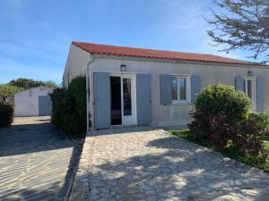 ChassironLa maison du Bout du Monde, Jacuzzi, Climatisation, 4 chambres, Plage à 600M et Phare à 1Km的街上有门的小白色房子