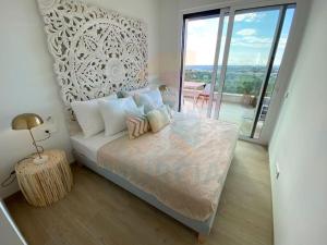 a bedroom with a bed with a table and a balcony at Limonero16 in Orihuela Costa