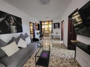 ein Wohnzimmer mit Sofa und Fernseher in der Unterkunft Affordable holiday accommodation for large families and groups at Las Canteras beach with 3 Bedrooms and Free Parking in Las Palmas de Gran Canaria