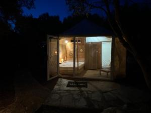 una casa de cristal con cama en la oscuridad en Glamping Tent Laskari, en Nea Moudania