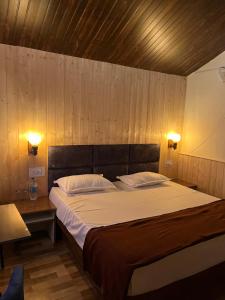 a bedroom with a large bed with two pillows at Serene River Cottages Sadhupul in Jūnga