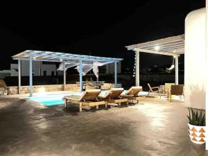 grupa krzeseł siedzących w nocy przy basenie w obiekcie Casa Zen Mykonos w mieście Mykonos