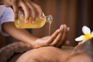 een vrouw die een massage krijgt met een fles honing bij Afrika Zimmer mit Bergblick in Emmetten