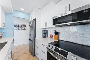 a kitchen with white cabinets and a stainless steel appliances at Our House at the Beach 604E By Beachside Management in Siesta Key