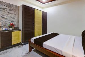 a bedroom with a bed with wooden doors and a dresser at Collection O SV Delight Inn in Hyderabad