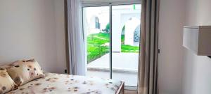 a room with a bed and a sliding glass door at Magnifique Appartement de Luxe à Tanger avec Vue sur la Mer et Accès Piscine in Tangier