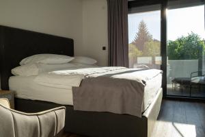 ein Schlafzimmer mit einem Bett und einem großen Fenster in der Unterkunft Villa of Senses in Bihać + 51 Fotos