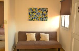 a couch in a room with a painting on the wall at MendoApart completo con cochera in La Cieneguita