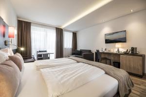 een hotelkamer met een groot bed en een bureau bij zum Senner Suites Zillertal in Schlitters