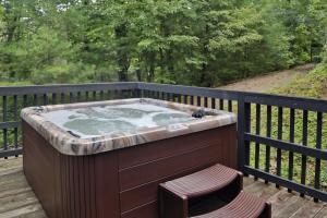 a hot tub on a deck with a chair at Apple Blossom by Eden Crest in Pigeon Forge