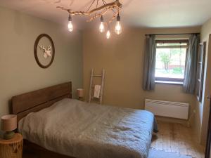 a bedroom with a bed and a window at Szarvas és Bagoly Kalandház in Szarvas