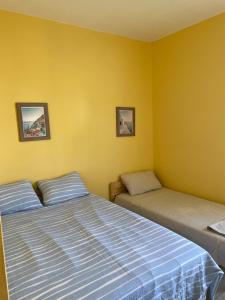 Bel appartement a tanger beach في طنجة: سريرين في غرفة بجدران صفراء +17 صورة