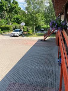 a fence with flowers on it with a car in a parking lot at Viesu nams Pupa in Kuldīga