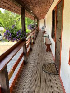 a porch of a house with benches and flowers at Viesu nams Pupa in Kuldīga