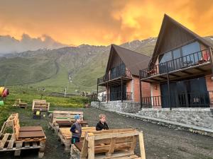 two children standing in front of a building with mountains at Royal Cottages in Kazbegi