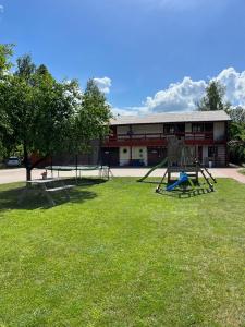 un parque con parque infantil frente a un edificio en Viesu nams Pupa, en Kuldīga