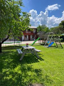 una mesa de picnic en un parque con dos columpios en Viesu nams Pupa, en Kuldīga