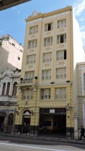 un grand bâtiment jaune sur le côté d'une rue dans l'établissement Hotel Belas Artes, à Rio de Janeiro