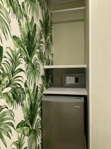 a refrigerator in a kitchen with a tropical wallpaper at WH HOTEL in San Andrés