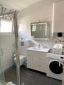 a bathroom with a sink and a washing machine at Apartmani Villa Adriatic in Vir