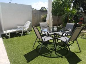 a patio with a table and chairs on grass at Appartement dans villa avec jardin et piscine privée in Marguerittes