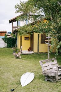 uma prancha de surf deitada na relva em frente a uma casa em Pousada Lua de Java - Casa Bali em Praia do Rosa