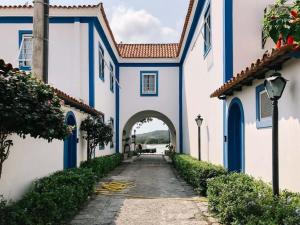 Une ruelle entre deux bâtiments blancs et bleus dans l'établissement Flat 218 no bairro da Passagem em Cabo Frio, à Cabo Frio