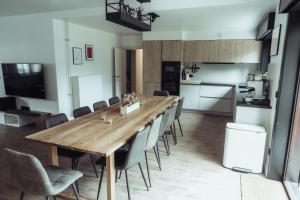 eine Küche und ein Esszimmer mit einem Holztisch und Stühlen in der Unterkunft Arrivée - 5-Star Luxury Sports-Inspired Holiday House in Merelbeke
