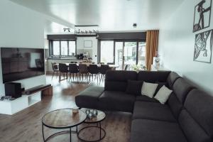 ein Wohnzimmer mit Sofa und Tisch in der Unterkunft Arrivée - 5-Star Luxury Sports-Inspired Holiday House in Merelbeke