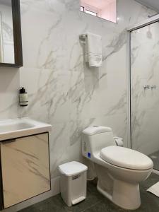 een badkamer met een toilet, een wastafel en een douche bij WH HOTEL in San Andrés