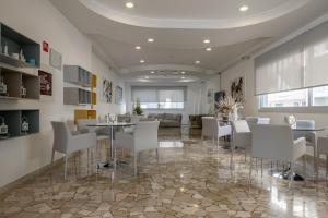 a dining room with white chairs and a table at Hotel Bristol in Caorle