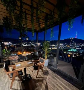 a balcony with a table and a view of a city at Hotel Livin in Tbilisi City