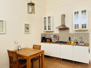 kuchnia z białymi szafkami i drewnianym stołem w obiekcie Casa Ripa Guest House w mieście Cupramontana
