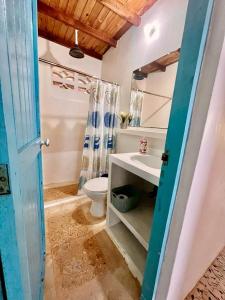 La salle de bains est pourvue de toilettes blanches et d'un lavabo. dans l'établissement Casa Manglar, à Tolú